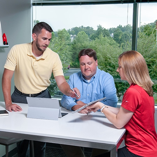 Ryan Bonilla and the Rocket IT staff talking in a conference room with tablet computers